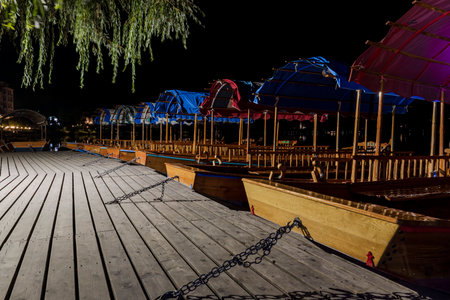 The historic pletna rowing boats of Bled docked on the quay at nightの写真素材