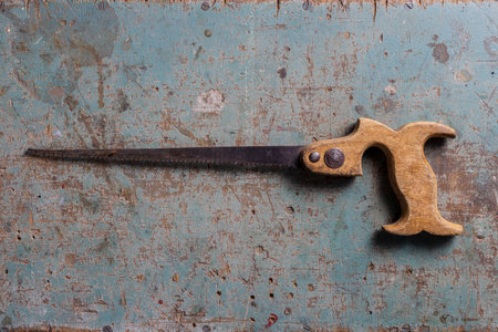 Vintage keyhole saw on a rustic surface flat lay view from aboveの写真素材