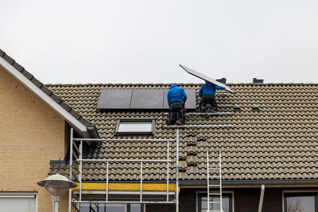 Barendrecht, the Netherlands - 2020-12-03: Two technicians installing photovoltaic panels on the roof of a homeのeditorial素材