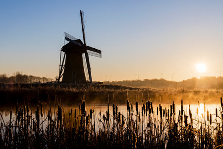 Dutch windmill in Rotterdam Pendrecht by the water at sunriseのeditorial素材