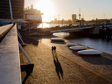 Rotterdam, the Netherlands - 2022-010-18: Couple enjoying a romantic sunset stroll along the Rotterdam waterfront near the cruise terminalのeditorial素材