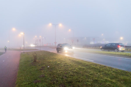 Barendrecht, the Netherlands - 2022-01-12: Cars driving in dangerous fog conditionsのeditorial素材