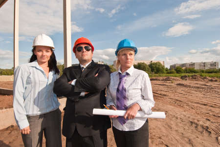 Director and engineers on construction site of shopping center