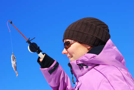 Young attractive girl on winter fishing