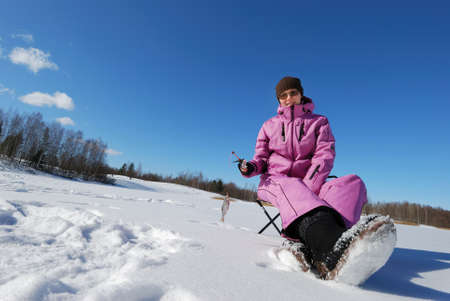 Young attractive girl on winter fishingの写真素材