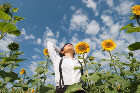 Young adult  woman relaxation on  sunflowers field