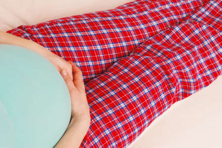 Young happy pregnant woman touching stroking belly on last month of pregnancyの写真素材