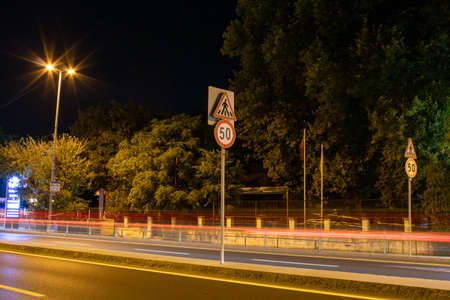 50 km limitation traffic sign on the road. Light trails of cars and street lights shining around.の写真素材