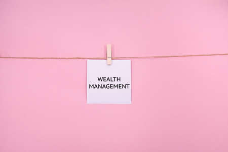 White paper note with text WE WANT WEBINAR on clothespins on pink background