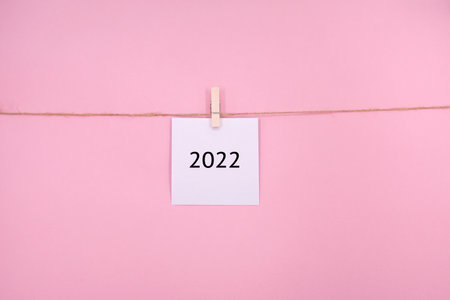 White sticky note with the word 2022 on PINK backgroundの写真素材