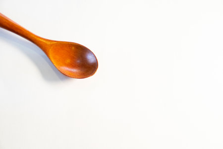 Wooden spoon on white background, top view, copy space.の写真素材