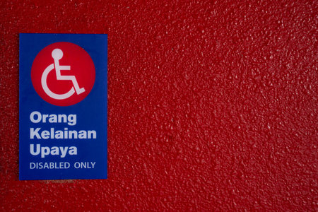 Handicap sign on a red wall with space for text.の写真素材