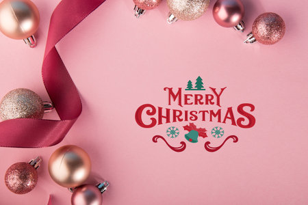 From above shot of composed red curly ribbon with shining baubles on pink background.の写真素材