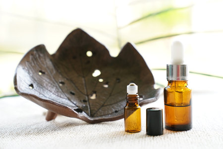 Essential oil in a glass bottle on a natural background with a leafの写真素材