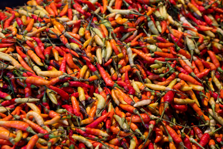 Pile of red and orange chili peppers for sale at a market