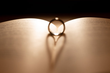 Wedding rings on the pages of a book in a heart shapeの写真素材