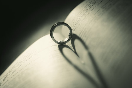 Wedding ring on the pages of a book in a heart shapeの写真素材