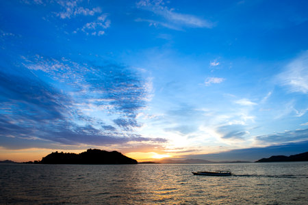 Sunset on the sea with a boat and islands in the background