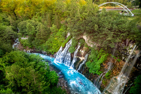 Shirahige Waterfall with deep cobalt blue hue Biei river flow beneath, Biei, Kamikawa Subprefecture, Hokkaido, Japanの写真素材