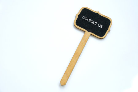 A small Contact  Us  note on blackboard on white backgroundの写真素材