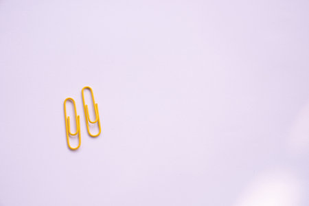 Yellow paper clips close-up on a white backgroundの写真素材