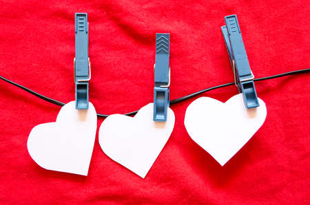 Three Paper Hearts on a Clothesline on a Textured blue Background の写真素材