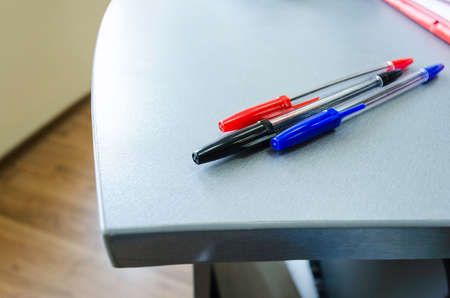 Three multicolor felt pens on wooden deskの写真素材