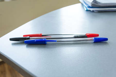 Three multicolor felt pens on wooden deskの写真素材
