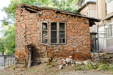 Old wall with broken window and treeの写真素材