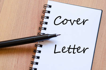 Notepad and pen on wooden background and cover letter text conceptの写真素材