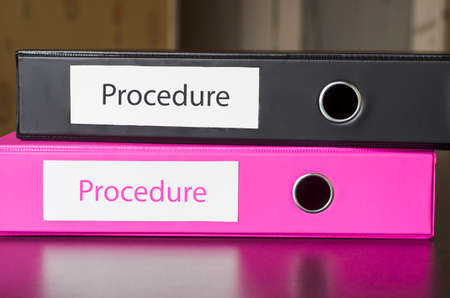 Bright office folders over dark background and procedure text conceptの写真素材
