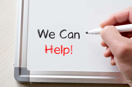 Human hand writing we can help on whiteboardの写真素材