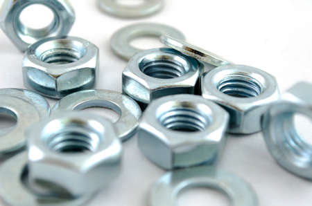 Several metal screw washers and nuts isolated on white background.