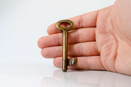 Hand holding key on isolated on white backgroundの写真素材