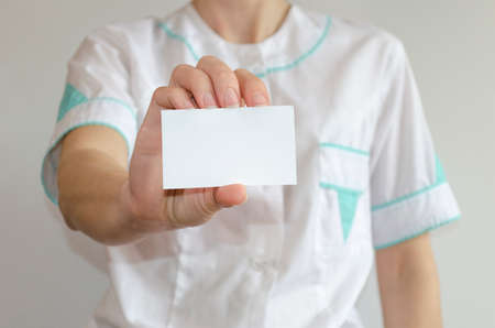 Doctor's hand holding blank business cardの写真素材