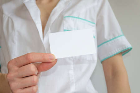 Doctor's hand holding blank business cardの写真素材