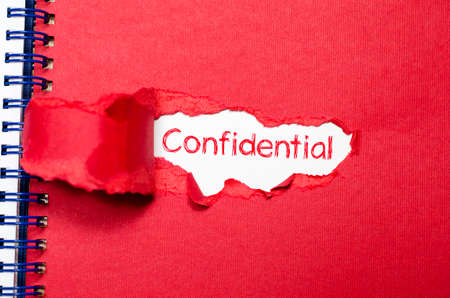 The word confidential appearing behind torn paper.の写真素材