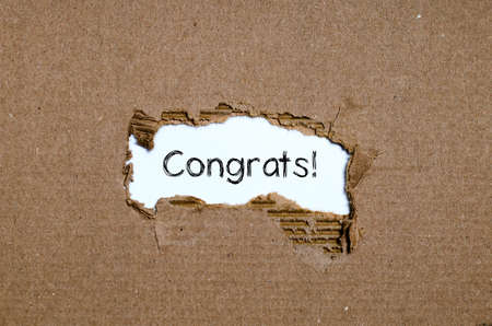 The word congrats appearing behind torn paper.の写真素材