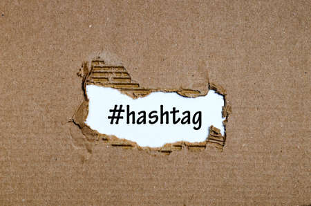 The word hashtag appearing behind torn paperの写真素材