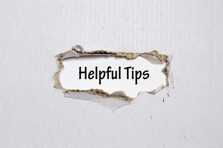 The word helpful tips appearing behind torn paperの写真素材