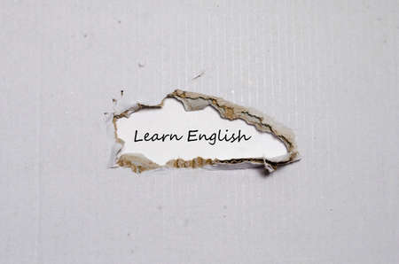 The word learn english appearing behind torn paperの写真素材