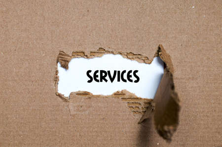 The word services appearing behind torn paperの写真素材