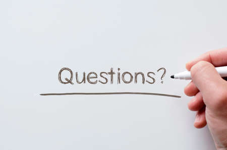 Human hand writing questions on whiteboardの写真素材