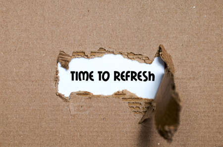 The word time to refresh appearing behind torn paperの写真素材