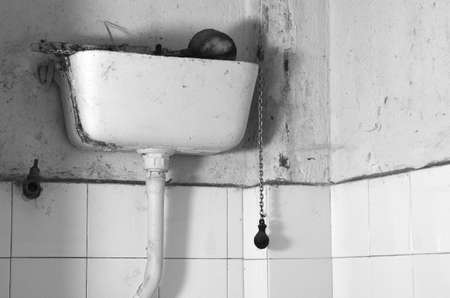 Dirty old flush toilet mechanism black and white themeの写真素材