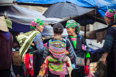Sapa, Lao Cai, Vietnam - 6 May 2014: Hmong tribal women with baby in national clothes on the local market, Sapa, Northern Vietnam on 06 May 2014.のeditorial素材