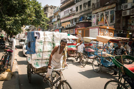 Delhi, India - September 18, 2014: Rickshaw carrying heavy cargo under the heat on the street of Old...