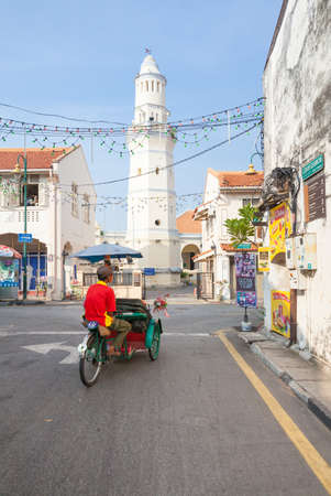 George Town,  Malaysia - March 21, 2016: Cycle rickshaw is riding down the street in front of the Lebuh Aceh Mosque. on March 21, 2016 in George Town, Penang, Malaysia.のeditorial素材