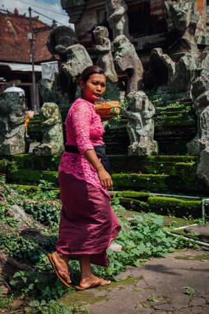 Ubud, Indonesia - March 01, 2016: Balinese woman in traditional clothes making offerings in the temple, Ubud, Bali, Indonesia on March 01, 2016のeditorial素材