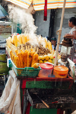 Street food stall with grilled corn under the rain, Ubud, Bali, Indonesiaのeditorial素材